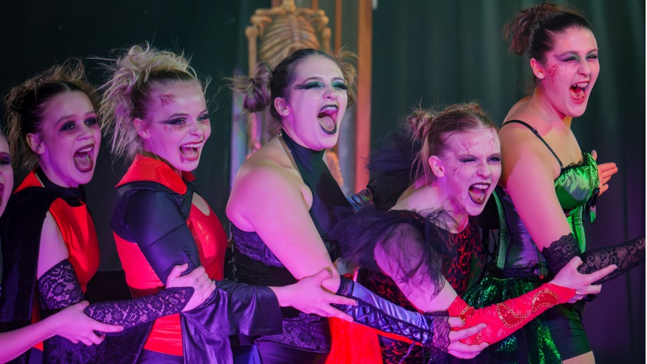Performers on stage in Halloween costumes.