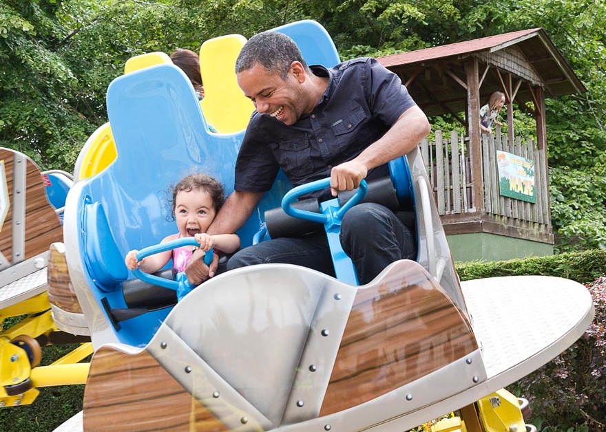 Man and small girl riding theme park ride at Gulliver's Kingdom